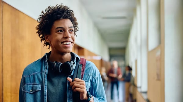 student smiling with backpack and headphones